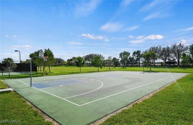 view of sport court with a yard