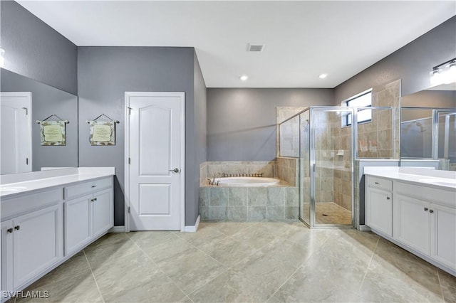 bathroom with vanity and shower with separate bathtub