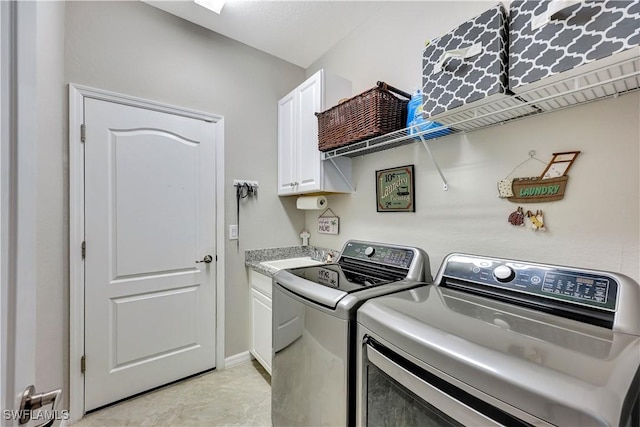 washroom featuring cabinets, sink, and washing machine and dryer