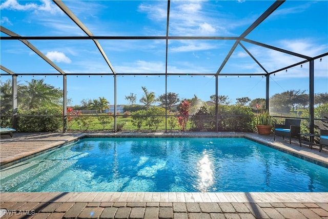 pool featuring glass enclosure and a patio