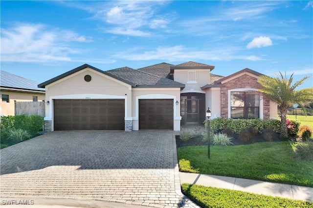 view of front of home featuring decorative driveway, fence, a garage, and stucco siding