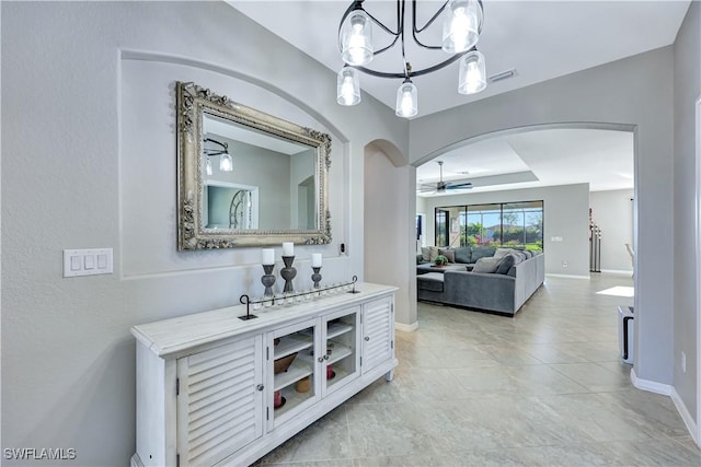 bathroom with visible vents, baseboards, and ceiling fan with notable chandelier