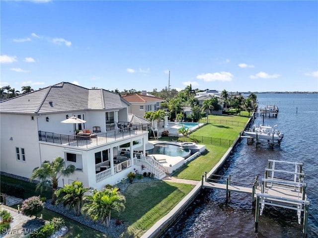 exterior space featuring a water view, a balcony, and a lawn