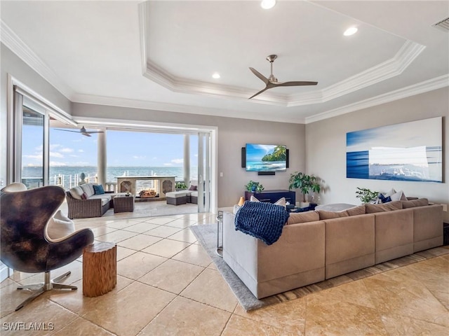 living room with crown molding, ceiling fan, and a tray ceiling