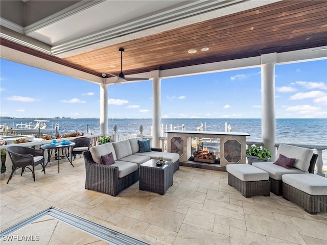 view of patio featuring a water view and an outdoor living space with a fireplace