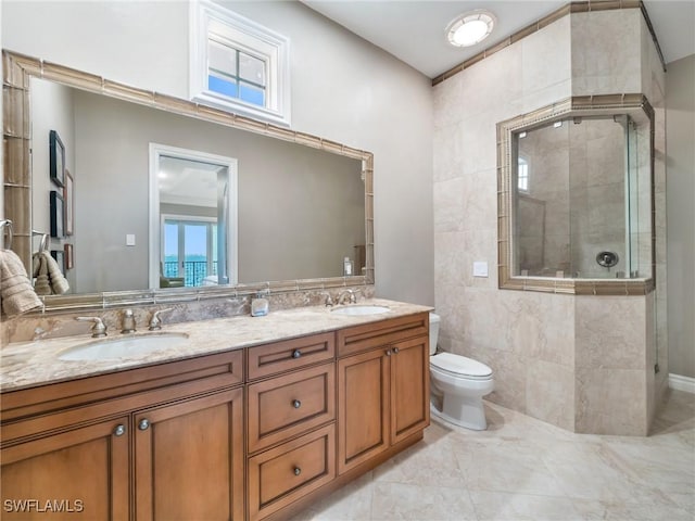 bathroom featuring vanity, a shower with shower door, and toilet