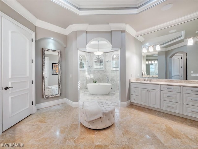 bathroom featuring ornamental molding, a tray ceiling, separate shower and tub, and vanity