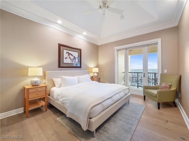 bedroom featuring ornamental molding, access to exterior, light hardwood / wood-style floors, and a tray ceiling