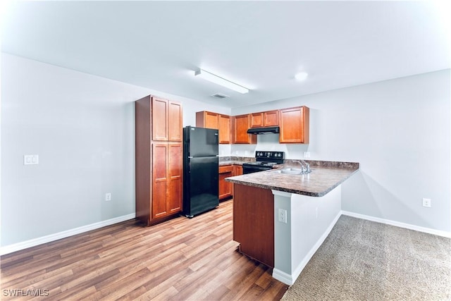 kitchen featuring kitchen peninsula, sink, light hardwood / wood-style flooring, and black appliances