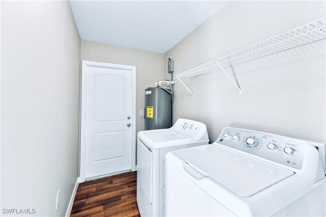 laundry area with dark wood-type flooring, washing machine and clothes dryer, and water heater