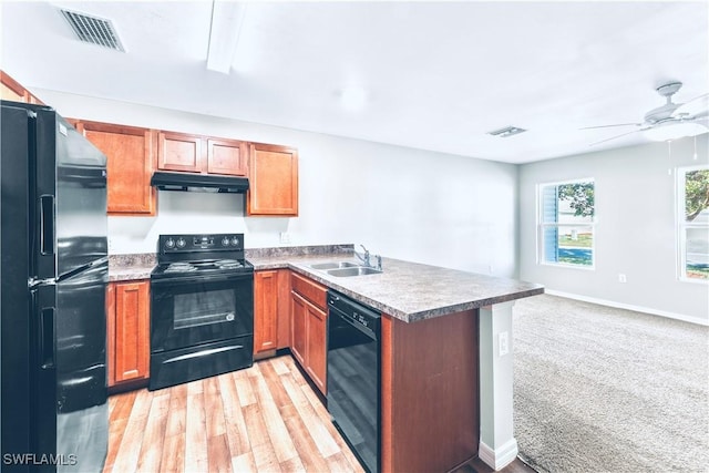 kitchen with sink, black appliances, kitchen peninsula, light carpet, and exhaust hood