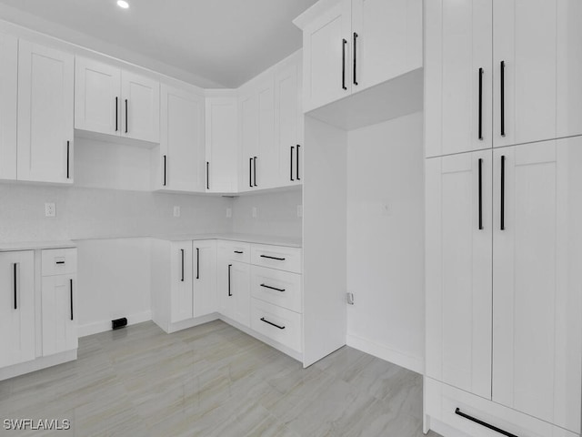 kitchen with white cabinetry and decorative backsplash