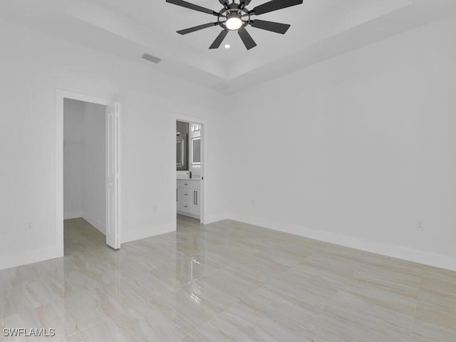 unfurnished room featuring ceiling fan and a tray ceiling