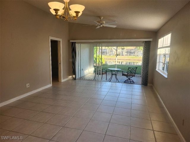 tiled spare room featuring lofted ceiling and ceiling fan with notable chandelier