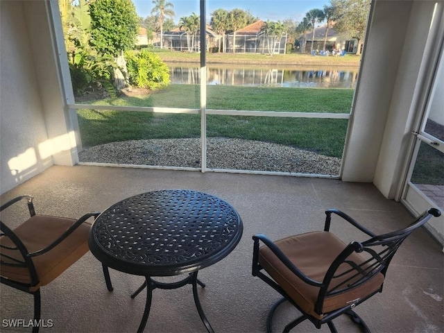 sunroom featuring a water view