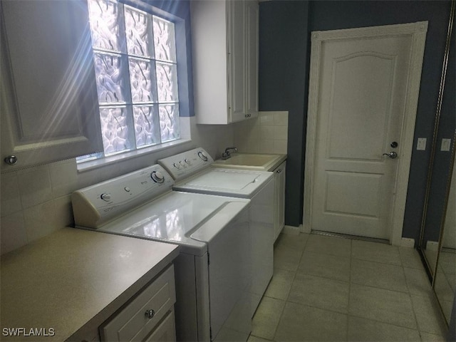 laundry area with cabinets, separate washer and dryer, sink, and light tile patterned floors