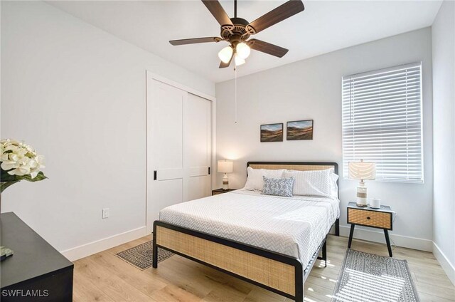 bedroom featuring ceiling fan, a closet, and light wood-type flooring