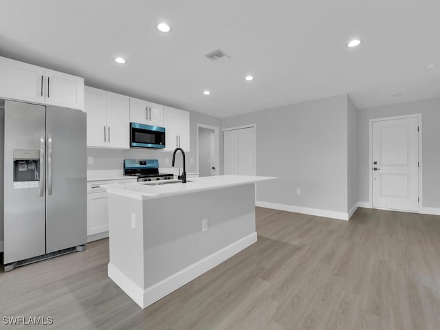 kitchen with white cabinetry, a center island with sink, and appliances with stainless steel finishes