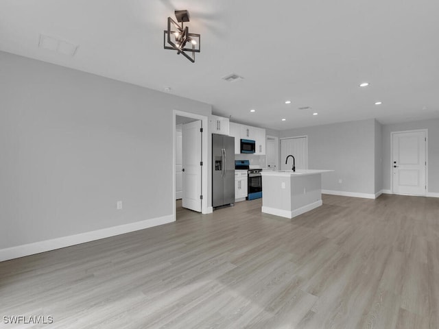 unfurnished living room with sink and light hardwood / wood-style flooring