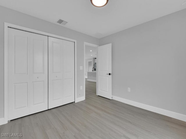 unfurnished bedroom with light hardwood / wood-style floors and a closet