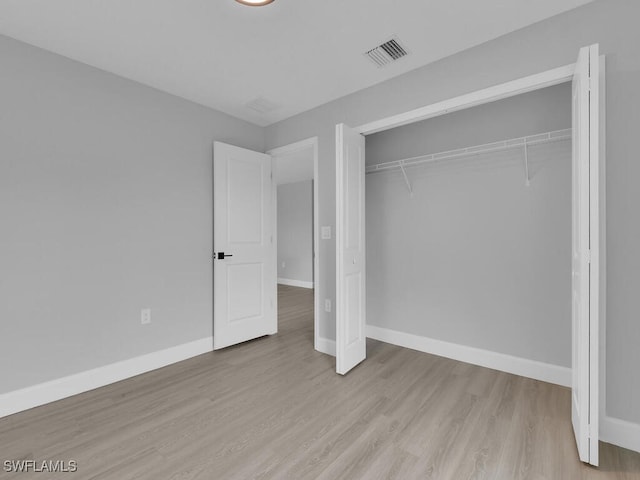 unfurnished bedroom with a closet and light hardwood / wood-style flooring