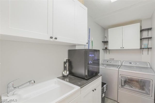 laundry room with cabinets, washer and dryer, and sink