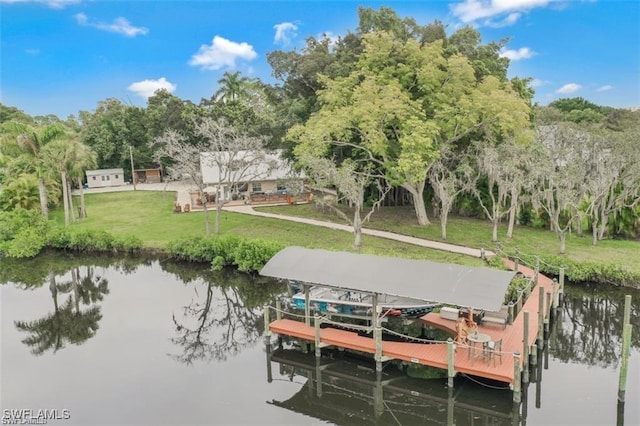 view of dock with a water view and a yard