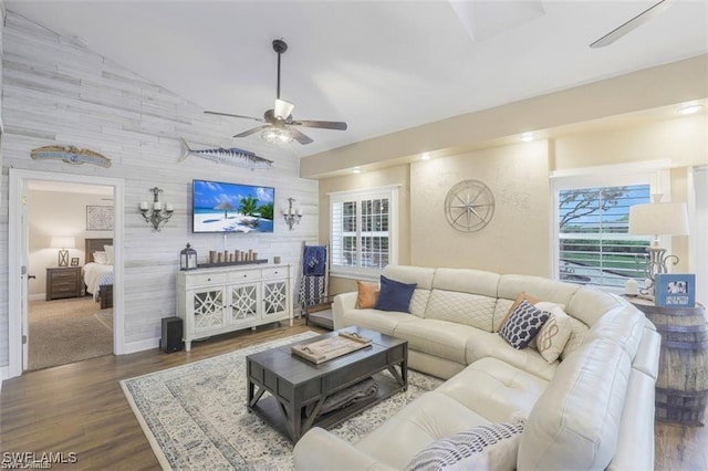 living room with ceiling fan, dark hardwood / wood-style flooring, and vaulted ceiling