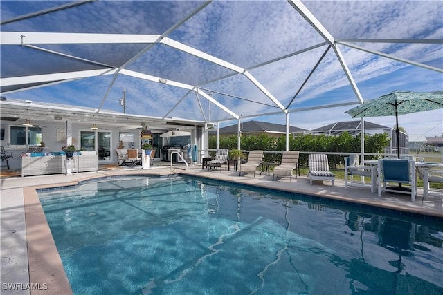 view of pool featuring a patio area, ceiling fan, and glass enclosure