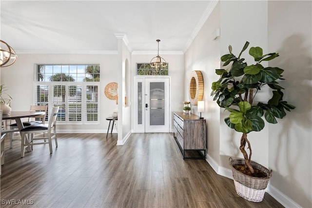 foyer entrance featuring an inviting chandelier, crown molding, dark wood finished floors, and baseboards