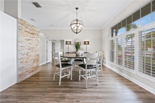 dining area featuring visible vents, wood finished floors, an inviting chandelier, and crown molding