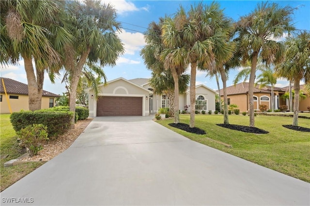 mediterranean / spanish-style house featuring a front yard, stucco siding, driveway, and an attached garage