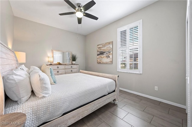 bedroom featuring wood tiled floor, a ceiling fan, and baseboards