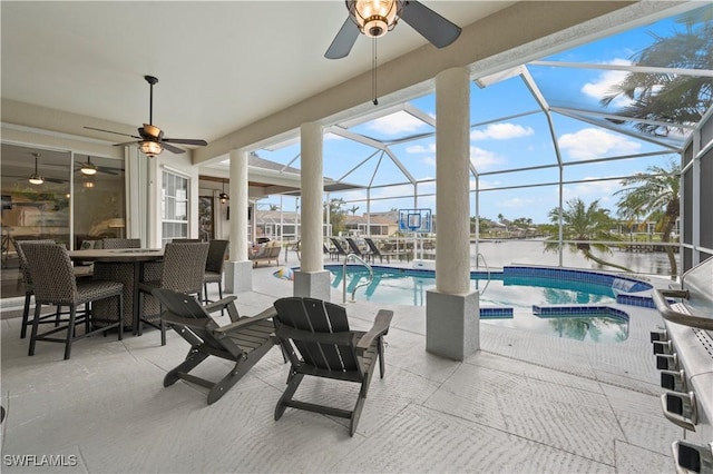 view of pool with a patio area, ceiling fan, and glass enclosure