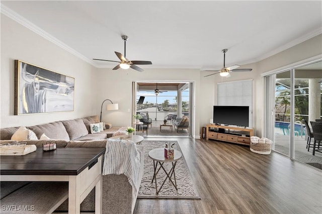 living room with wood-type flooring, ornamental molding, and ceiling fan