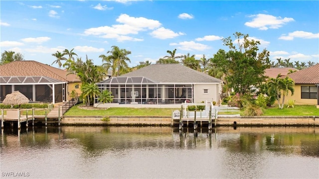 back of property with a lanai and a water view