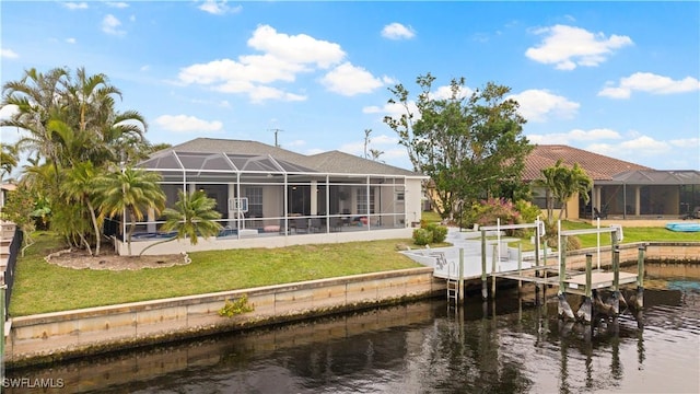 rear view of property with a lawn, a water view, glass enclosure, and boat lift