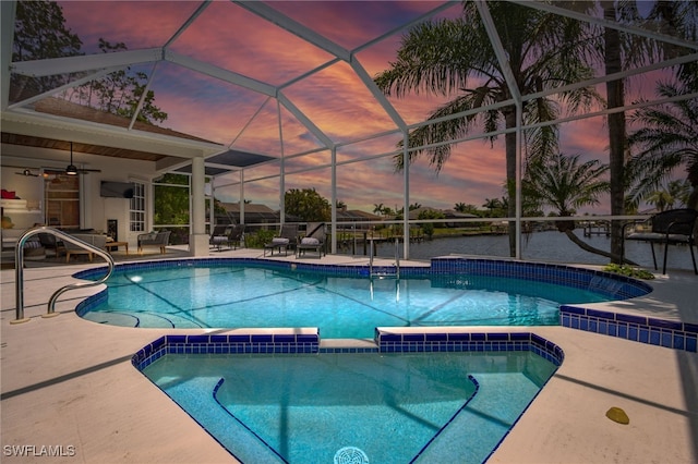 view of pool with a lanai, ceiling fan, a pool with connected hot tub, and a patio area