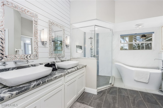 full bath featuring a soaking tub, a stall shower, double vanity, and a sink