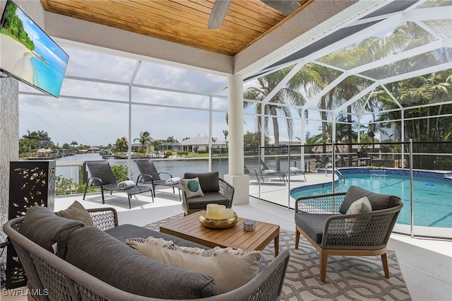 pool with a lanai, an outdoor hangout area, a water view, and a patio area