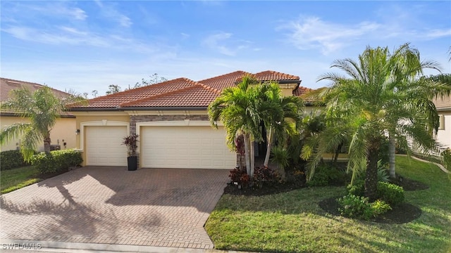 mediterranean / spanish-style home featuring a garage and a front yard