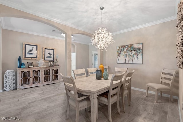 dining area featuring a notable chandelier, ornamental molding, and light wood-type flooring