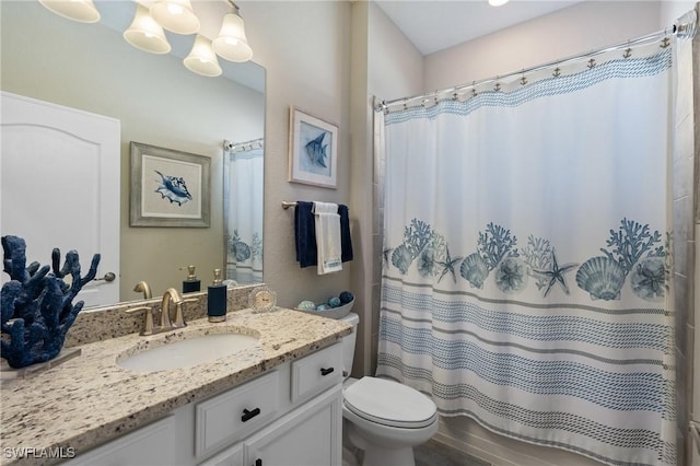 bathroom with walk in shower, vanity, and toilet