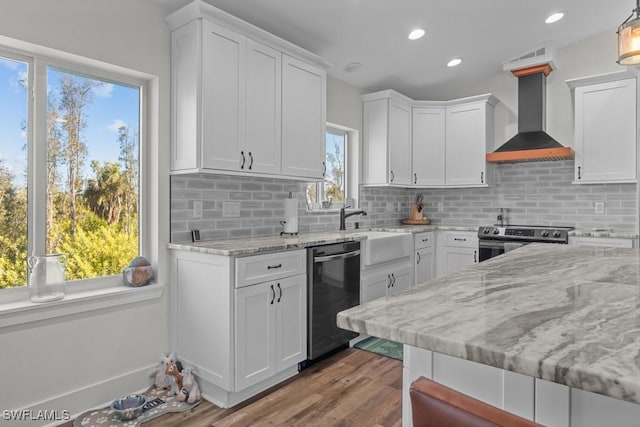 kitchen with white cabinetry, appliances with stainless steel finishes, and wall chimney range hood