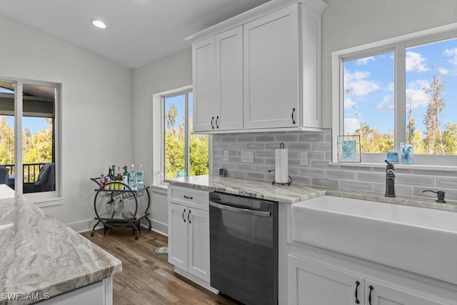 kitchen featuring sink, white cabinetry, dishwasher, light stone countertops, and decorative backsplash