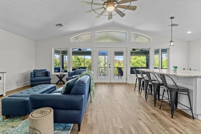 living room featuring vaulted ceiling, light wood-type flooring, ceiling fan, and french doors