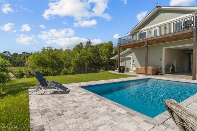 view of pool featuring a hot tub, a patio, and a lawn