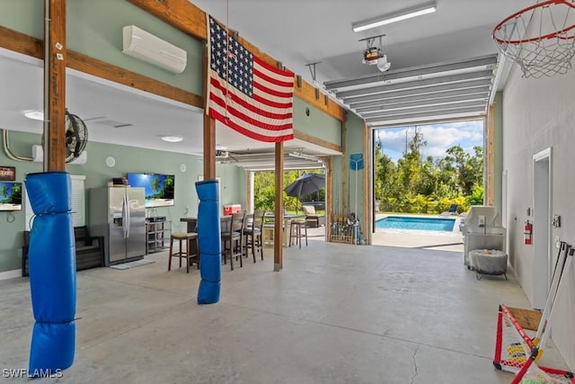 garage with a wall unit AC and stainless steel refrigerator with ice dispenser