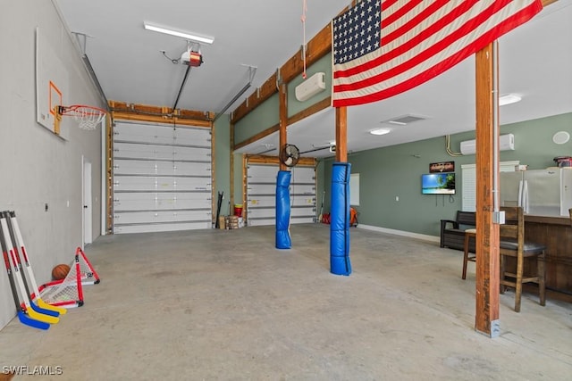 garage with a garage door opener, stainless steel fridge, and a wall unit AC