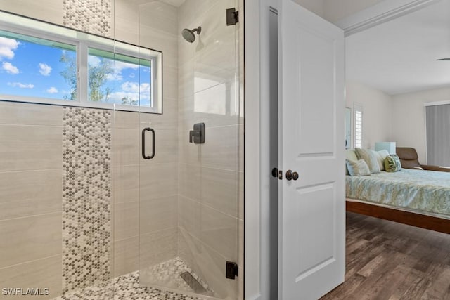 bathroom with hardwood / wood-style floors and a shower with shower door